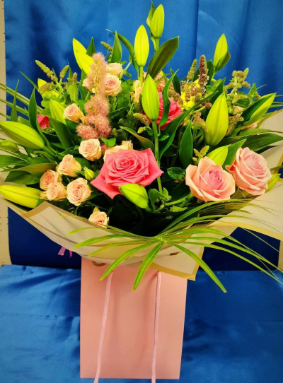 Blush & Bloom Hand-Tied - Romantic pink rose and lily hand-tied bouquet with spray roses and seasonal foliage. Handcrafted by Four Seasons Florist for birthdays and special occasions.