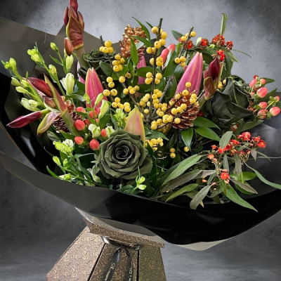 Dark Desire - A luxurious Prestige bouquet featuring pink lilies, deluxe roses, berries, amaryllis and alstroemeria, complemented by beautiful seasonal foliage.
